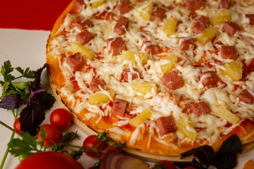 Hot italian pizza on a table with vegetables