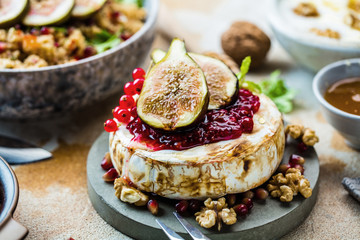 close-up view of tasty healthy dish with fruits, nuts, honey, camembert cheese, couscous and...