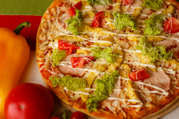 Hot italian pizza on a table with vegetables