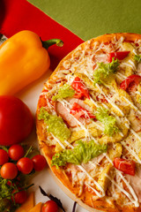 Hot italian pizza on a table with vegetables