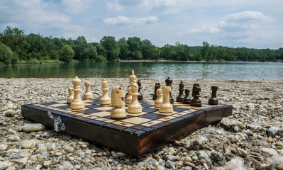 Playing chess near the lake Štrkovisko in Senec, Slovakia. Chessboard on a stone beach with a great landscape