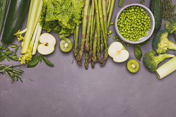 Fresh organic spring vegetables and spices on grey stone table