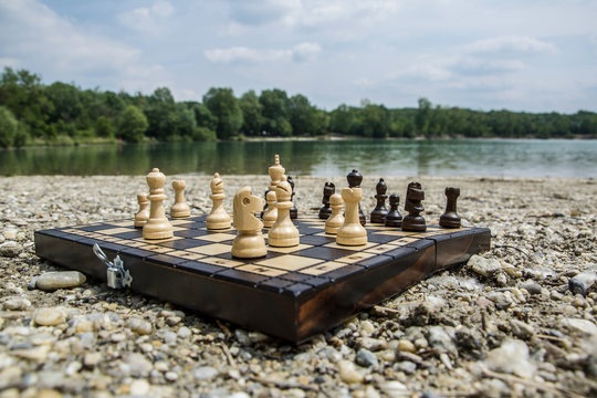 Playing chess near the lake &Scaron;trkovisko in Senec, Slovakia. Chessboard on a stone beach with a great landscape