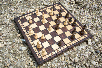 Chessboard lying on a stones outside. Playing chess outdoors.