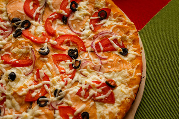Hot italian pizza on a table with vegetables