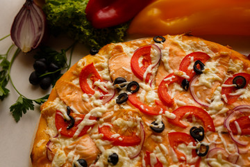 Hot italian pizza on a table with vegetables