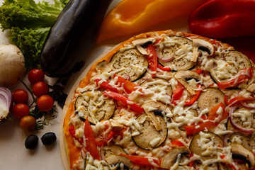 Hot italian pizza on a table with vegetables