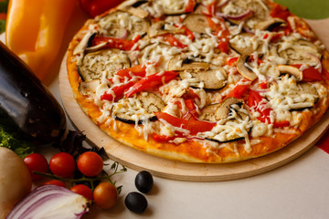 Hot italian pizza on a table with vegetables