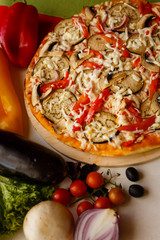 Hot italian pizza on a table with vegetables