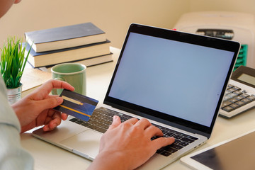 Fototapeta na wymiar Hands holding credit card and using laptop. Online shopping