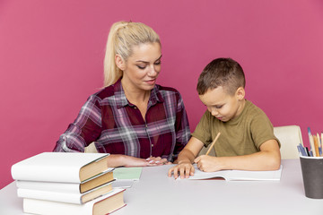 Tutor with child doing homework together in the pink room