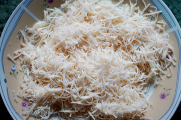 Grated cheese ready to cook. Pizza preparation.