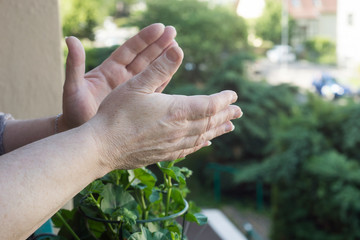 Closeup of hands of woman aplauding medical workers at the window during the covid-19 pandemic