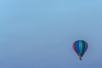 Globo aerostático de colores volando con un cielo azul