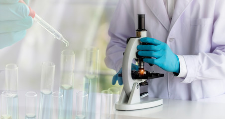 laboratory concept; scientist uses a microscope, with blurred of research activity in the laboratory