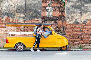 Fototapeta premium Traveler japanese girl hollding map travel query for the way with old man driver taxi or tuk tuk touring.