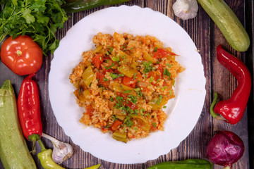 Tasty vegetarian guvech with potatoes, carrots, and other vegetables on a plate, top view