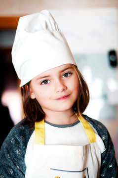 ni&ntilde;a cocinera con delantal y gorro blaco