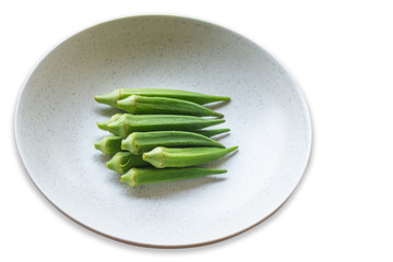 Okra, Lady's finger, Gombo, Gumbo, Bendee, Quimbamto (Scientific name: Abelmoschus esculentus)stack in a plates,isolated on a white background.