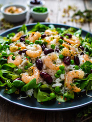 Prawns with rice and vegetables on wooden table