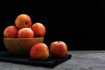 apples in a wooden bowl on a dark background