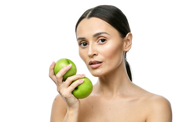 close-up portrait of a girl with clear skin holding a apple to her face, isolated on a white background