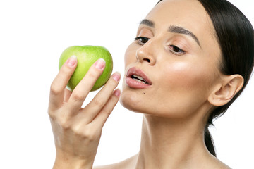 close-up portrait of a girl with clear skin holding a apple to her face, isolated on a white background