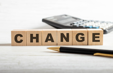 The word CHANGE made up of wooden cubes on a light background