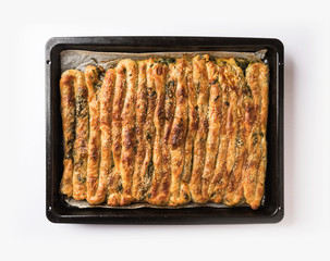 Traditional Turkish pastry with spinach. (Turkish Name: Ispanakli Kol Boregi). Handmade pastry with spinach filling on white background..