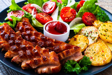 Grilled sausages and vegetables on wooden board
