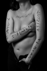 part of a young woman's body with the words affront,cruelty,inequality on a black...