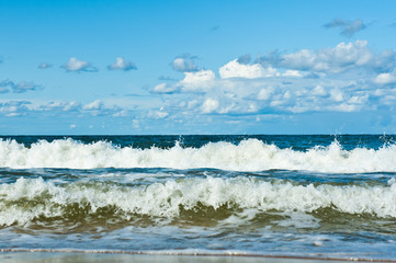 The Baltic Sea. Waves and blue sky with white clouds 
