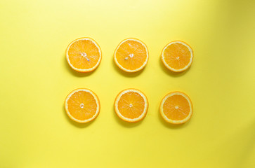 Minimal food concept. Orange fruit on a bright yellow background. Free space for text. Top view. Minimalism. Creative fruits.