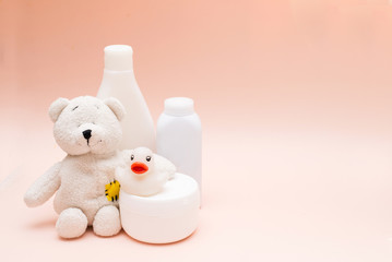 baby accessories for bath and toys on pink background with copy space