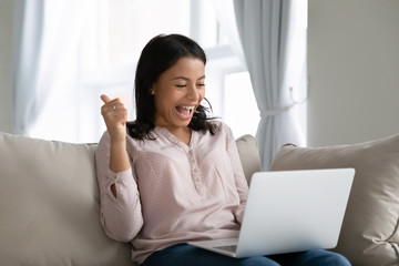 African woman sit on sofa hold notebook on lap feels happy showing thumbs up check bank application...