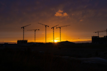 Fototapeta na wymiar construction cranes at sunset