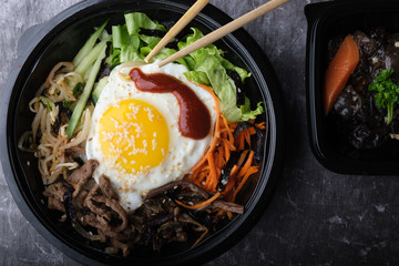 Korean dish bibimbap. Top view close up. Nearby are the Korean sticks.