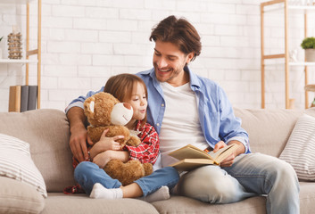Little girl and her father enjoying book together