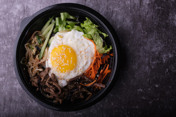 Korean dish bibimbap. Top view close up. Nearby are the Korean sticks.
