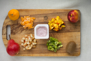 fruit salad serving ingredients slices cut on a wooden Board isolate on a white background kiwi nectarine pear Mandarin