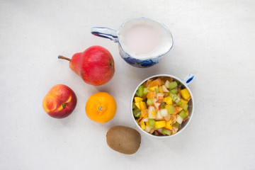 fruit salad serving in a Cup decanter milkman with fresh milk yogurt isolate on a white background...