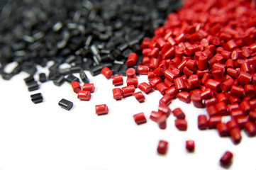Black and red plastic polymer granules isolated on white 