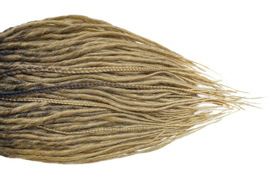 Dreadlocks are laid out on a white background and taper to the ends. Blonde braids on a white background at close range