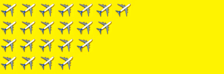 Pattern made of model airplane on yellow background. Travel vacation summer concept. Top view, flat lay. Airlines out of service concept. Out of business airliners. Corona virus pandemic.