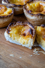 Pasteis de Nata or Belem Tart. Portuguese Custard made with Egg, Cinnamon, Sugar and Flour on Wooden Plate.
