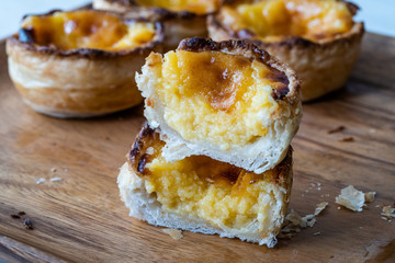 Pasteis de Nata or Belem Tart. Portuguese Custard made with Egg, Cinnamon, Sugar and Flour on Wooden Plate.