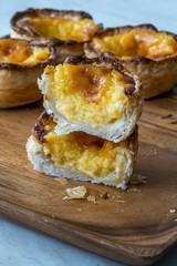 Pasteis de Nata or Belem Tart. Portuguese Custard made with Egg, Cinnamon, Sugar and Flour on Wooden Plate.