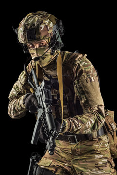 Soldier holding assault rifle. Uniform conforms to special services of the Russian Federation. Shot in studio. Isolated with clipping path on black background
