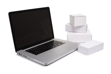 Online shopping, searching products and home delivery. Cardboard boxes or parcel and a laptop.