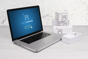 Online shopping, searching products and home delivery. Cardboard boxes or parcel and a laptop.